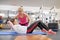 Middle-aged woman doing sports exercise in fitness center. Personal gym trainer assisting mature woman. Health fitness sport age