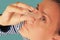 Middle aged woman drops eyes. Macro closeup image of face. Medical procedure at home. Girl holding eyedropper bottle and dropping