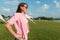 Middle-aged woman enjoys a vacation in summer recreation zone, female outdoors raising hands in sunlight park