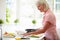 Middle Aged Woman Following Recipe On Digital Tablet