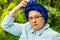 Middle-aged woman with glasses and a blue scarf resting