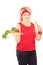Middle aged woman holding carrot and plate full of vegetables