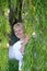 Middle-aged woman looks over willow branches