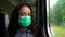 Middle aged woman with medical mask on face in suburban train, travelling to outskirts