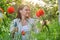 Middle-aged woman in nature cutting flowers red poppies