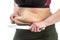 Middle-aged woman with obesity and saggy skin of the abdomen, on a white background, close-up. Knife, a symbol of