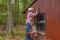 Middle aged woman painting shed