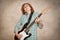 Middle aged woman playing electric guitar