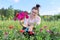 Middle-aged woman with pruning shears cutting bouquet of zinnia flowers