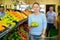 Middle-aged woman purchaser buying fresh apples in grocery store