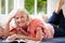 Middle Aged Woman Reading Magazine Lying On Sofa