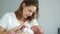 A middle-aged woman is rocking her newborn baby, gently holding his hand. Surrogate motherhood. In vitro fertilization