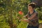 Middle-aged woman and a rose. The woman inhales the aroma of the rose at sunset. The rose shines at sunset