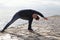 Middle aged woman at the seaside performing Yoga