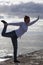 Middle aged woman at the seaside performing Yoga