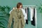 Middle aged woman shopping new dress clothes shelf green