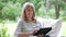 Middle Aged Woman Sitting Outdoors Using Digital Tablet