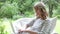 Middle Aged Woman Sitting Outdoors Using Laptop