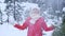 Middle-aged woman smiles and plays with snow in forest