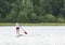 Middle aged woman on stand up paddle board in the lake in summer