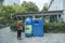 Middle-aged woman throwing beverage bottle trash into bottle-shaped trash