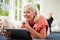 Middle Aged Woman Using Digital Tablet Lying On Sofa