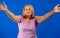 Middle blonde woman standing over blue isolated background looking at the camera smiling with open arms for hug. Cheerful