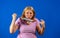 Middle blonde woman taking off her medical mask isolated on blue background