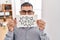 Middle east man with beard holding banner with swear words clueless and confused expression