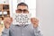 Middle east man with beard holding banner with swear words puffing cheeks with funny face