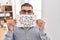 Middle east man with beard holding banner with swear words sticking tongue out happy with funny expression