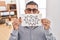 Middle east man with beard holding banner with swear words winking looking at the camera with sexy expression, cheerful and happy