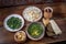 Middle Eastern cuisine dishes in ceramic plates on a wooden table. Soup with herbs and vegetables, rise with dry fruites, roasted