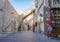 Middle Eastern father and two children wait at end of shady lane in Souq Waqif traditional markets