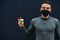 Middle eastern man in gray turtleneck and black face protect mask show Jordan flag isolated background