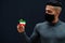 Middle eastern man in gray turtleneck and black face protect mask show Kuwait flag isolated background