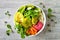 Middle eastern style Buddha bowl with green falafel, quinoa, butternut squash, tomatoes, avocado, beetroot hummus and tahini sauce