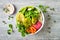 Middle eastern style Buddha bowl with green falafel, quinoa, butternut squash, tomatoes, avocado, beetroot hummus and tahini sauce