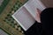 Middle eastern woman praying and reading the holy Quran