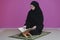 Middle eastern woman praying and reading the holy Quran
