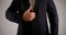 The middle plan of the male body in a dark suit. the man holds his hand in front of him and shows a thumbs up, scissors