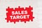 In the middle of the puzzles on a red background it is written - SALES TARGET