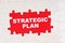 In the middle of the puzzles on a red background it is written - STRATEGIC PLAN