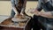 Middle shot of child making ceramics on pottery wheel with help of experienced adult