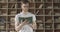 Middle shot of confident Caucasian man in eyeglasses turning book page and smiling. Portrait of focused young guy