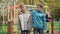 Middle shot of joyful Caucasian brothers hugging and looking at camera smiling standing in autumn park outdoors. Happy