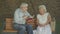 Middle shot of old Caucasian couple sitting on bench and discussing book. Portrait of senior beautiful woman and