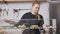 Middle shot portrait of positive cafe worker taking sweet dessert on counter and walking away. Plus-size Caucasian woman