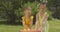 Middle shot of positive sisters playing with duckling toys on sunny summer meadow outdoors. Portrait of charming