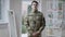 Middle shot of proud handsome young man in military uniform posing at home indoors. Confident Caucasian recruit looking